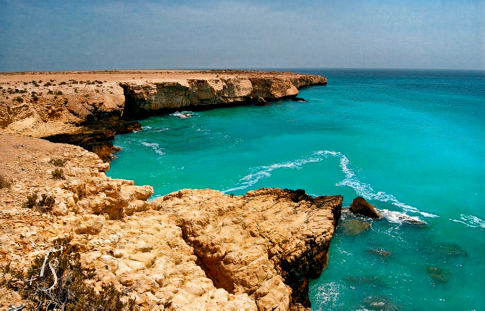 Breathtaking coastal scenery at Fins Beach, offering a tranquil oasis with its sandy shores, clear blue waters, and majestic cliffs.