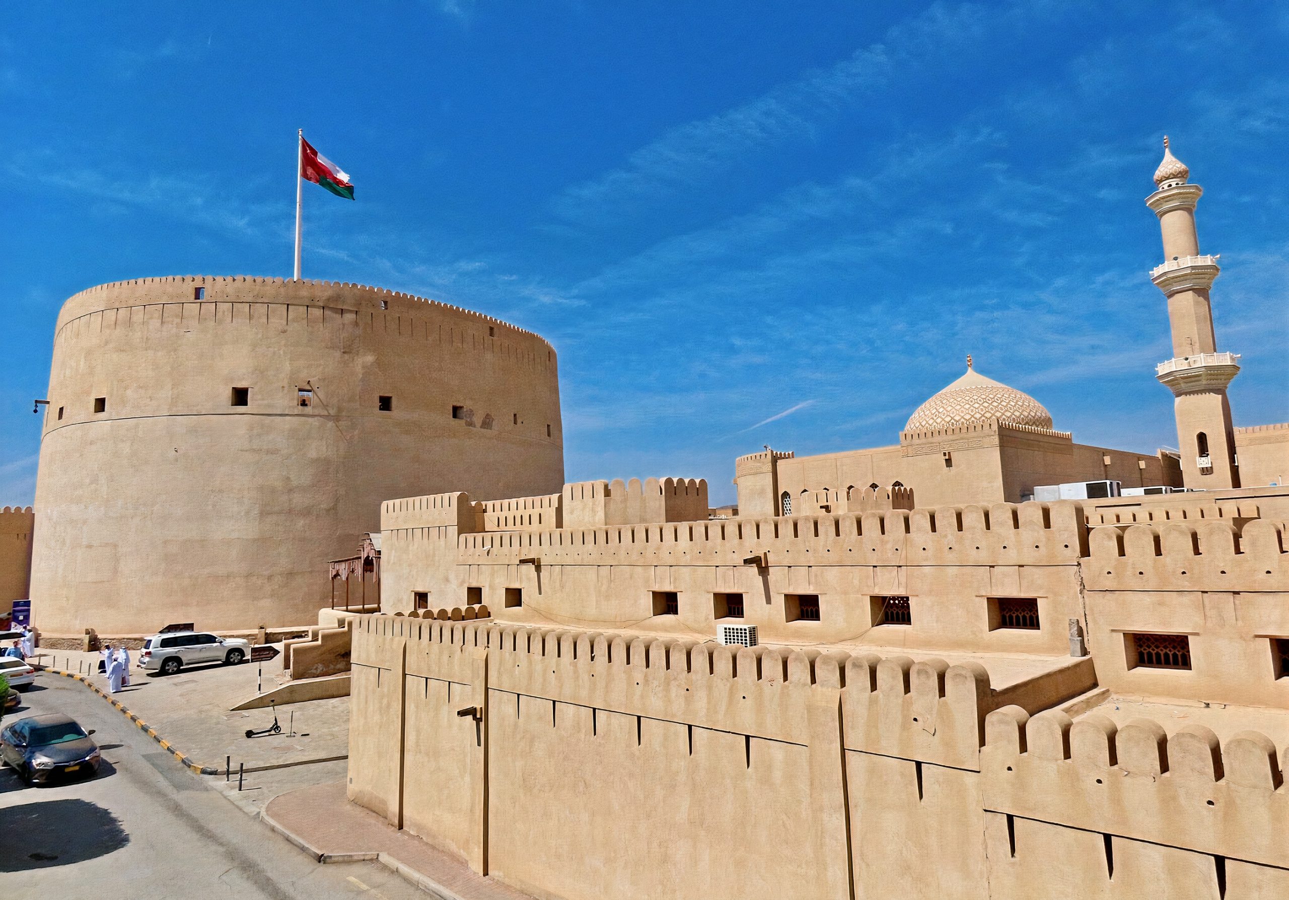 Impressive view of Nizwa Fort, a historic landmark in Nizwa, Oman. The imposing fort stands tall, showcasing its architectural grandeur and providing panoramic views of the ancient town and surrounding mountains. This well-preserved fort offers a glimpse into the rich history and military prowess of the Yaruba dynasty.