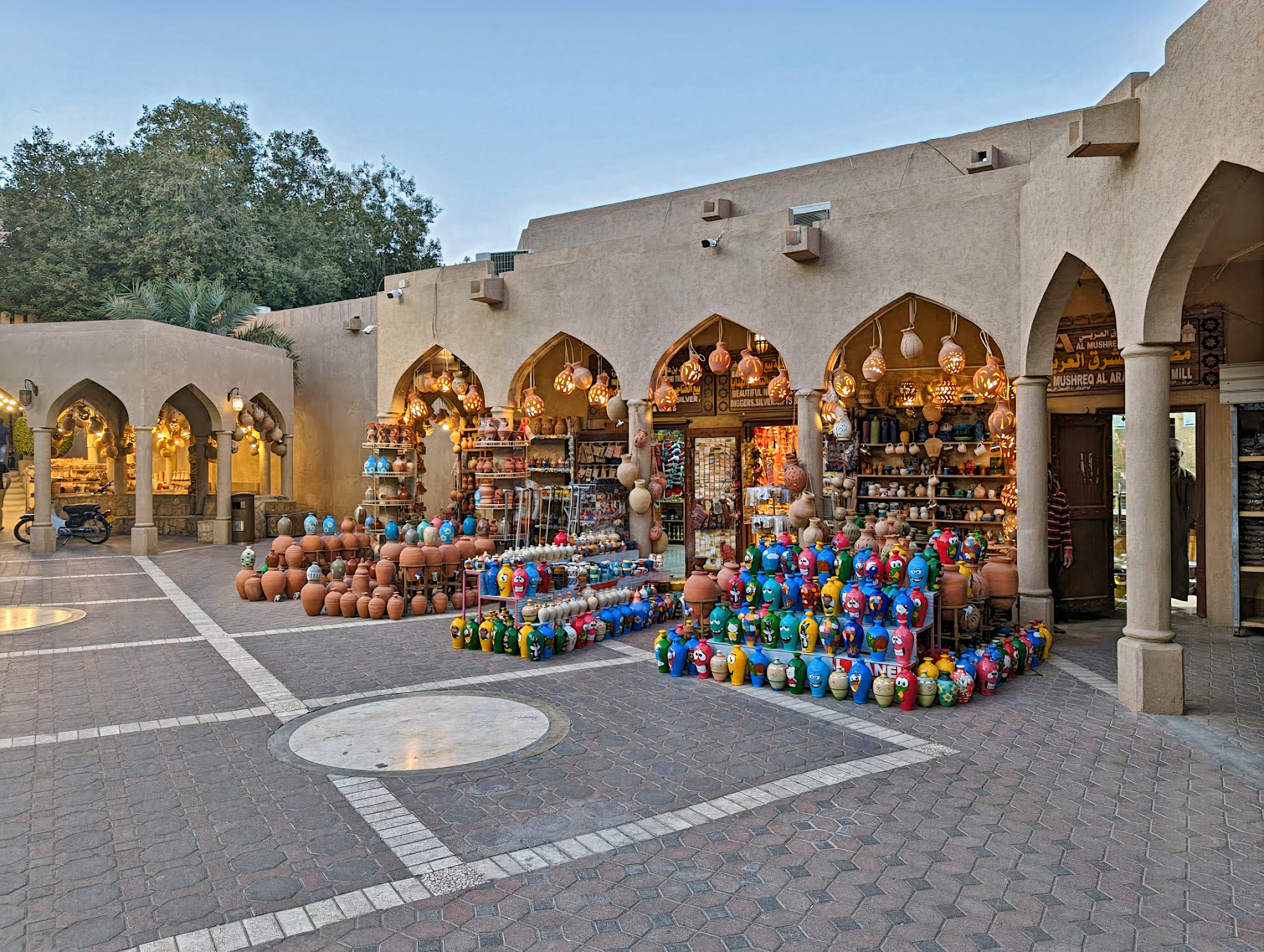 Vibrant scene of Nizwa Souq, a bustling marketplace in Nizwa, Oman. The lively atmosphere is filled with colorful stalls offering a variety of goods, from pottery and jewelry to fresh produce. Visitors can immerse themselves in the rich cultural experience and local traditions of Oman at this vibrant souq.