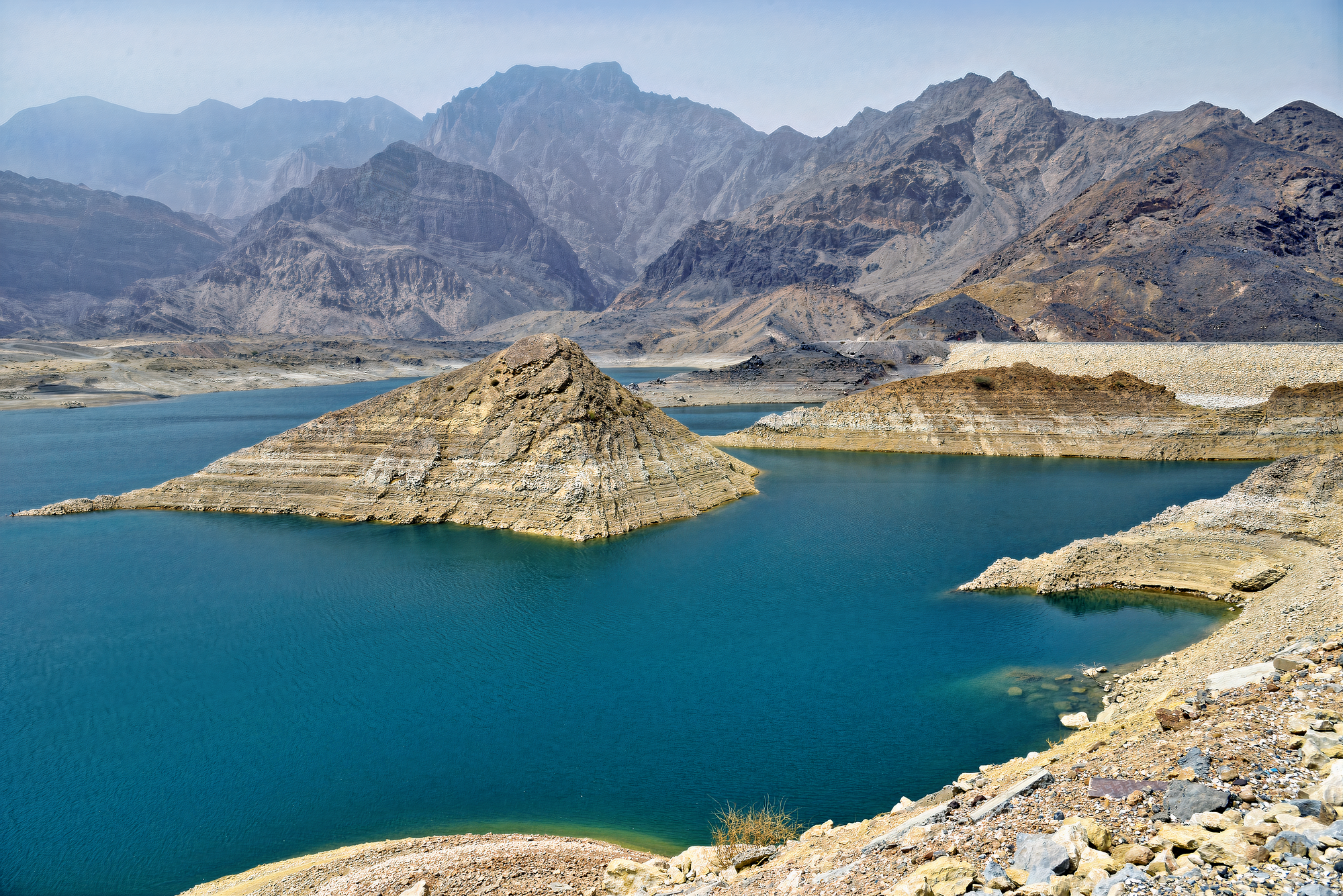 Scenic beauty of Wadi Dayqah Dam, nestled among towering cliffs and surrounded by lush greenery.