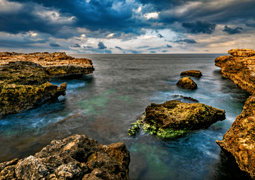 A mesmerizing view of Sur's coastline on a cloudy day, with the sea stretching into the distance.