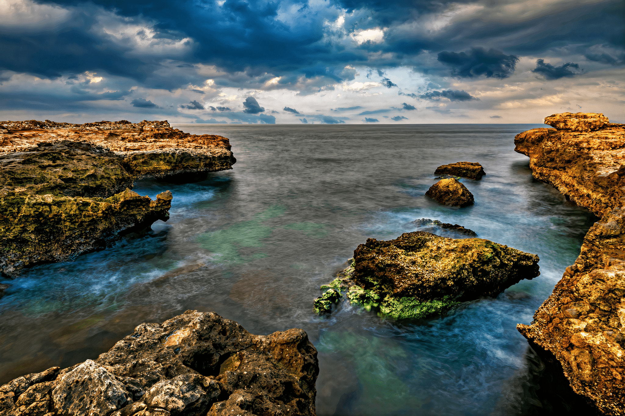 A mesmerizing view of Sur's coastline on a cloudy day, with the sea stretching into the distance.