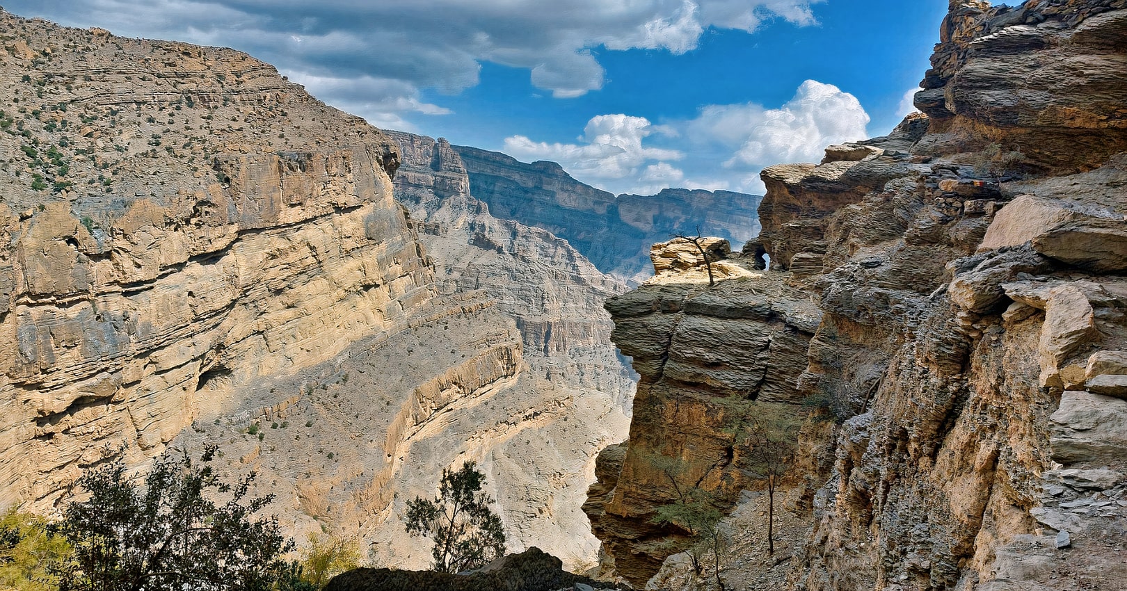 Thrilling moments on the W6 Balcony Trail as hikers navigate the rugged path amidst the Jebel Shams wilderness.