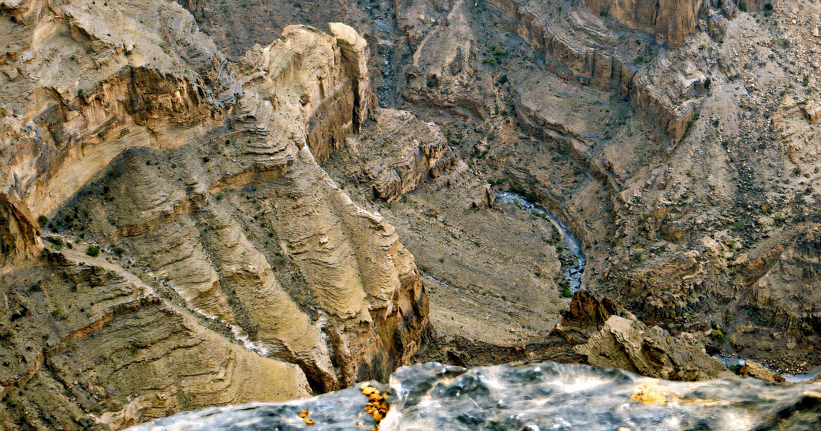 A group of adventurers conquering the W6 Balcony Trail, with the stunning Jebel Shams landscape in the background.